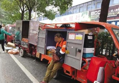 11月21日，芦淞市场，一位快递员在等待客户接收包裹（图文无关）（记者谢慧摄）